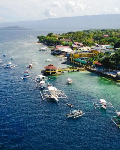 Aerial view of sandy beach with tourists swimming in beautiful clear sea water of the Sumilon island beach landing near Oslob, Cebu, Philippines. - Boost up color Processing.